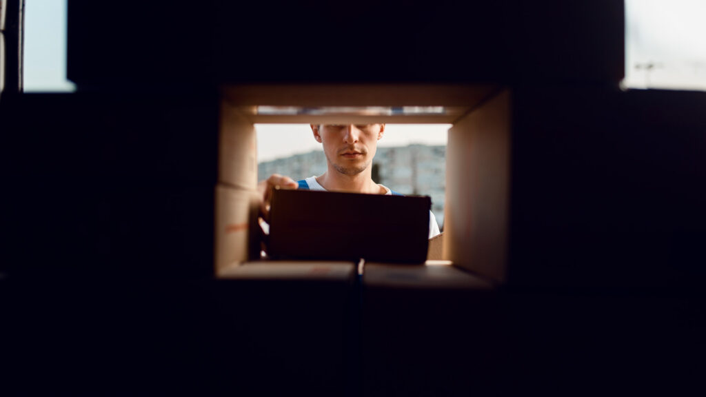 Delivery-Driver-Unloading-Boxes-Van-Dark